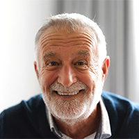 Close-up of a senior man in blue shirt smiling