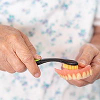 Close-up of dentures in Carlisle being brushed with a toothbrush