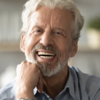 an older man smiling with new dentures