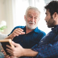 an older man conversing with a younger man