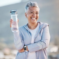 an older woman smiling while going on a hike