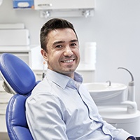 Male patient sitting in dental chair smiling