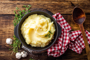 Bowl of mashed potatoes on wooden table